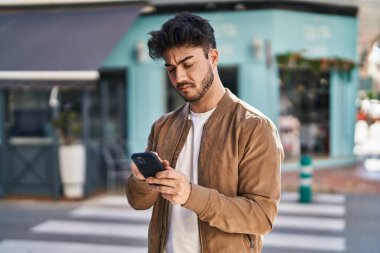 Sokakta akıllı telefon kullanan genç bir İspanyol.