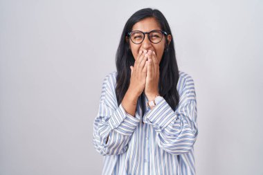 Gözlüklü genç İspanyol kadın gülüyor ve utanıyor kıkır kıkır kıkır gülüyor elleri, dedikodusu ve skandal konsepti ile ağzını kapatıyor 