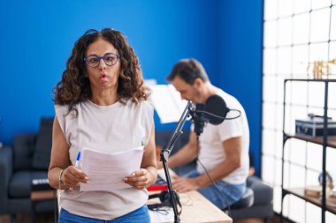 Orta yaşlı İspanyol bir kadın müzik stüdyosunda şarkı söylüyor. Ağzı ve şaşı gözleriyle balık yüzü yapıyor. Deli ve komik.. 