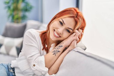 Young caucasian woman smiling confident sitting on sofa at home