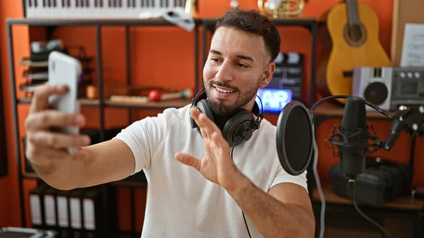 年轻的阿拉伯男子音乐家 戴着耳机 在音乐工作室里有视频通话 — 图库照片