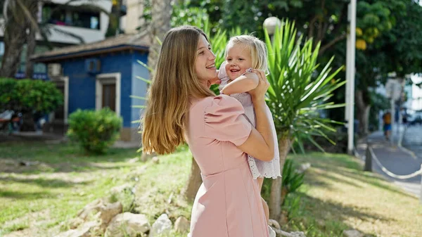 Confident Mother Arms Wrapped Her Daughter Smiling Joyfully Standing Sunlit — Stock Photo, Image