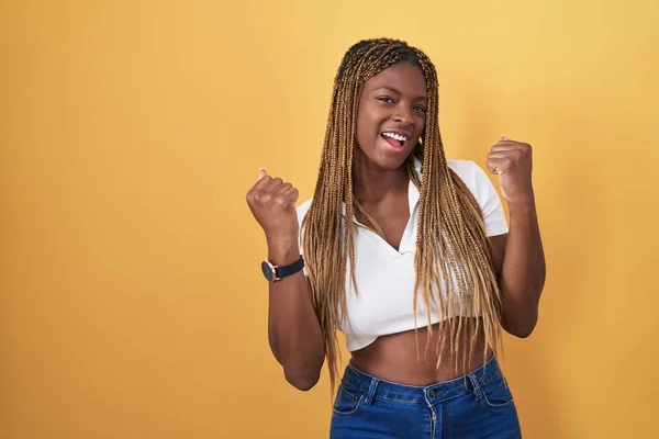 Sarı Arka Planda Örülü Saçları Olan Afro Amerikalı Kadın Kolları — Stok fotoğraf