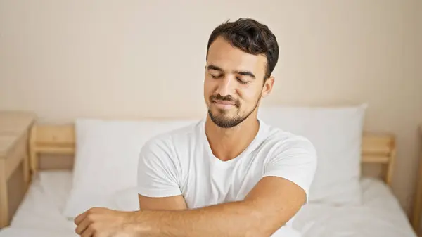 Молодий Іспаномовний Чоловік Посміхається Впевнено Сидить Ліжку Спальні — стокове фото