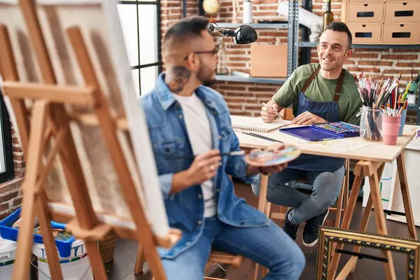 Two men artists smiling confident drawing at art studio