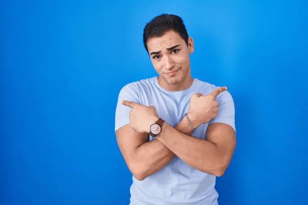 Jeune Homme Hispanique Debout Sur Fond Bleu Pointant Des Deux — Photo