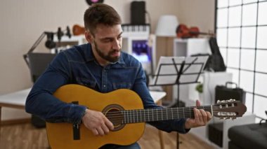 Gülümseyen genç İspanyol 'un duygusal tıngırtısı, klasik melodi müzik stüdyosunun akustik gitar performansına daldı.