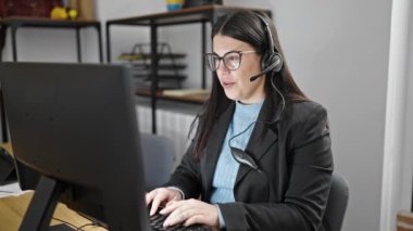 Siyah ceketli genç kız ofiste bilgisayarla çalışıyor..