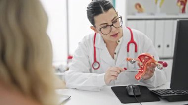 Kadın doktor jinekolog kadın üreme sisteminin modelini elinde tutuyor. 