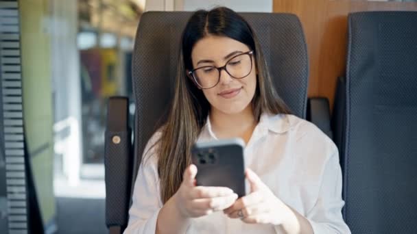Młoda Kobieta Korzystająca Smartfona Podczas Prowadzenia Pociągu Pasażerskiego — Wideo stockowe