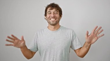 Işıldayan genç adam parmaklarıyla 10 numaralı tişörtü gösteriyor. Beyaz arka planda izole edilmiş olumlu bir jest.