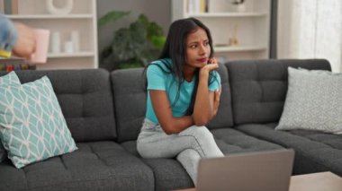 Güzel bir çift kanepede oturup kahvelerini yudumluyor.