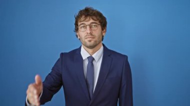 Gözünü kapatan bir elin arkasına, kederini saklayan, soğuk ifadeli, kör, genç İspanyol bir adam. Mavi yalıtılmış arka planda dokunaklı inkar kavramı.