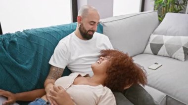 Güzel bir çift birlikte mutlu bir şekilde oturuyorlar. Oturma odalarında canlı bir sohbete dalıyorlar..