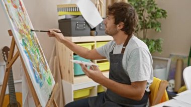 Yakışıklı sarışın, kendine güveni tam bir yetişkin. Üniversite sanat atölyesinde resim çizmekten zevk alırken gülümsüyor. Sakallı portresi, öğrenmeye dönen bir hobi, her fırça darbesiyle yaratıcılığı ateşliyor..