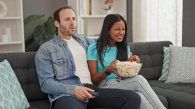 Evde patlamış mısır yiyen güzel bir çift.