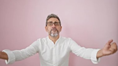 Çekici, beyaz saçlı ve gözlüklü İspanyol bir adam zaferi özgüvenle kutluyor. Eğlenceli, bulaşıcı bir kahkaha soğuk pembe bir arka planda bulaşıcı mutluluğunu yayıyor..