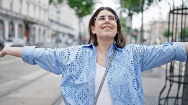 Güzel genç bir kadın gülümsüyor ve kameraya bakıyor.