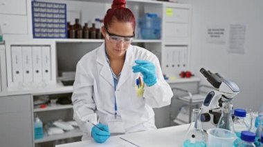 Bilimsel araştırmalara dalmış genç, ateşli, kızıl saçlı bir bilim adamının büyüleyici portresi, özenle notlar alıyor, hareketli bir tıp laboratuarında önemli bir örneği inceliyor..