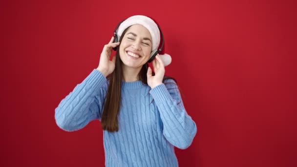 Mujer Jersey Navideño Escuchando Música Con Auriculares Sobre Fondo Rojo — Vídeo de stock