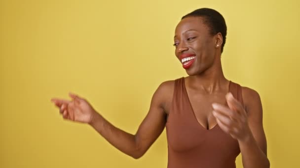 Radosna Afroamerykanka Pewnie Stoi Miga Promiennym Uśmiechem Przed Kamerą Wskazując — Wideo stockowe