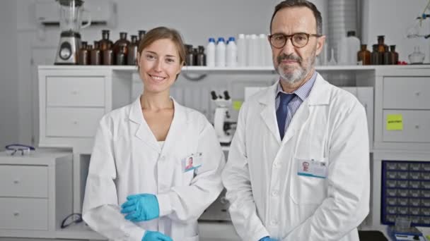 Δύο Χαμογελαστοί Επιστήμονες Που Δουλεύουν Μαζί Στο Εργαστήριο Στέκονται Σταυρωμένα — Αρχείο Βίντεο