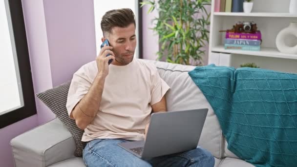 Estressado Jovem Hispânico Sentado Sofá Casa Envolvido Uma Conversa Telefônica — Vídeo de Stock