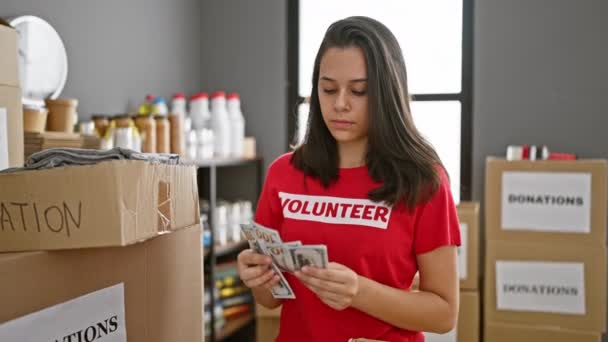 Jovem Hispânica Radiante Voluntária Contando Alegremente Doações Movimentado Centro Caridade — Vídeo de Stock