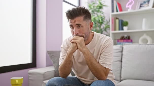 Pensive Young Hispanic Man Seeking Comfort Sofa Close Indoor Portrait — Stock Video