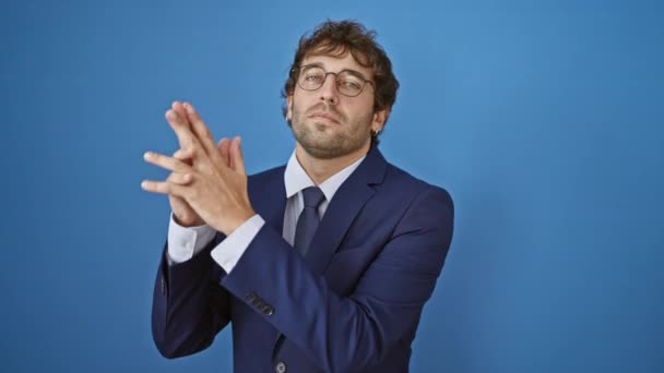 비즈니스 정장에 남자는 상징적인 제스처 손으로 파란색 배경에 — 비디오