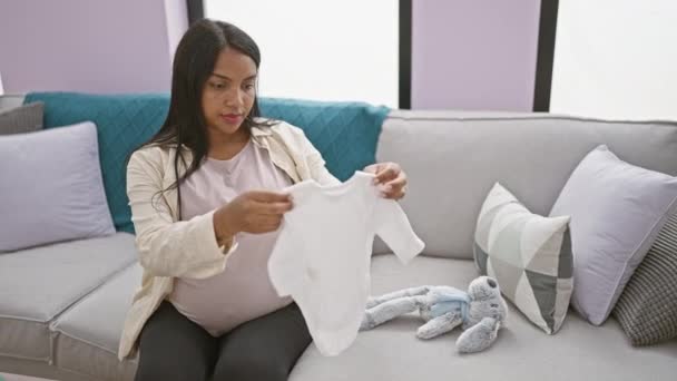 Stralende Jonge Zwangere Vrouw Vrolijk Vouwen Babykleertjes Aanraken Van Haar — Stockvideo