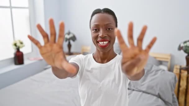 ベッドに横たわる陽気なアフリカ系アメリカ人女性 指で9番のジェスチャー ベッドルームの親密な快適さを指摘 — ストック動画