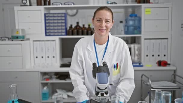 年轻貌美 金发碧眼的女科学家 自信满满满的 骄傲地站在实验室里 她的微笑证明了科学研究中的快乐 — 图库视频影像