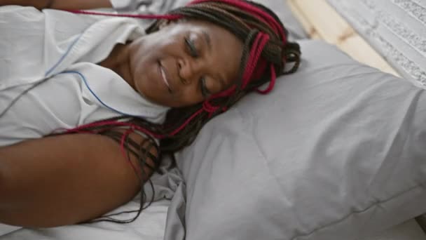 Усміхнена Афроамериканка Впевнено Насолоджується Релаксацією Лежачи Комфортно Ліжку Затишній Спальні — стокове відео
