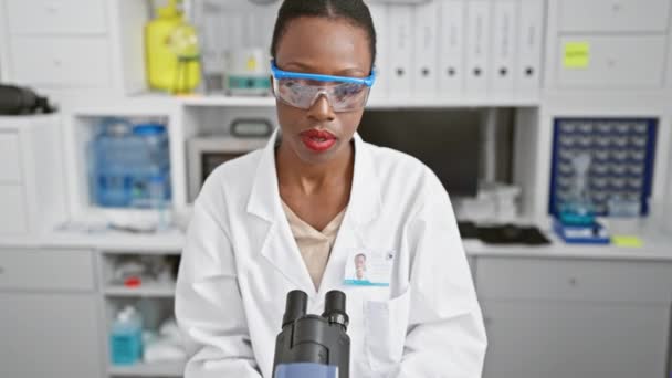 Ernsthafte Afroamerikanische Wissenschaftlerin Ihre Arbeit Vertieft Labortisch Zwischen Reagenzgläsern Sitzend — Stockvideo