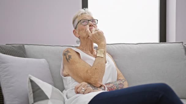Evdeki Oturma Odasındaki Kanepede Oturan Düşünceli Yaşlı Kadın Ciddi Bir — Stok video