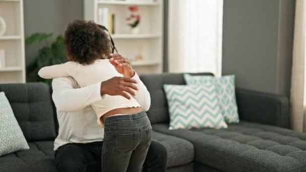 アフリカ系アメリカ人の父親と娘は自信を持って笑って 自宅でソファーに座って抱き合う — ストック動画