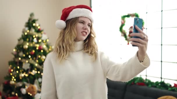 年轻的金发女人拿着圣诞礼物在家里用智能手机聊天 — 图库视频影像