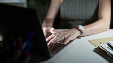 Genç sarışın iş kadını ofiste çalışırken laptop kullanıyor.