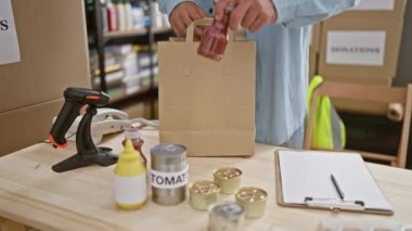 Gönüllü, enstantane, yakışıklı, İspanyol asıllı genç bir adam hayır kurumu bağışı için konserve kutusuna yiyecek dolduruyor. Vaktini ve enerjisini kamu hizmetinde gönüllü olarak harcıyor.