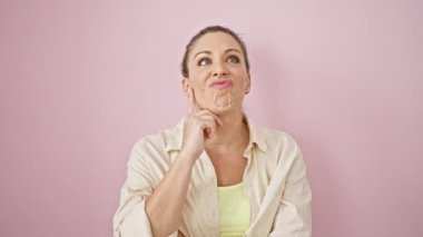 Genç sarışın kadının pembe arka planda gülümseyen bir fikri var.