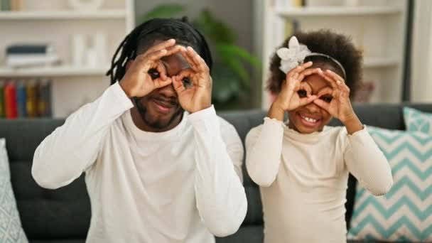 Afrykański Amerykański Ojciec Córka Siedzi Kanapie Robiąc Okulary Gest Uśmiechając — Wideo stockowe