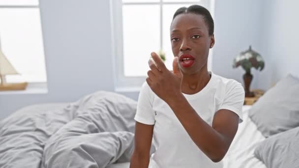 걱정된 아프리카계 미국인 여자가 침대에 누워서 손가락으로 가리키며 충격적인 표현을 — 비디오