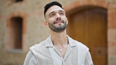 Sokakta ciddi bir ifadeyle duran İspanyol genç adam.