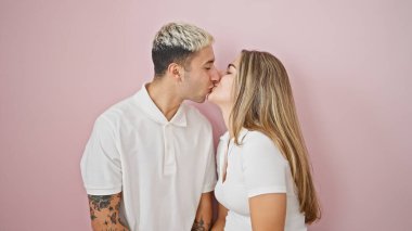 Güzel çift yan yana durmuş pembe arka planda öpüşüyor.
