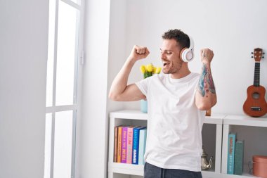 Genç İspanyol adam yatak odasında müzik dinliyor ve dans ediyor.