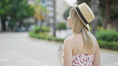 Sarışın genç kadın turist şehir haritasını geriye doğru tarıyor.