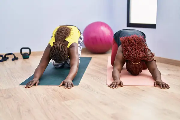 African american women stretching back at sport center