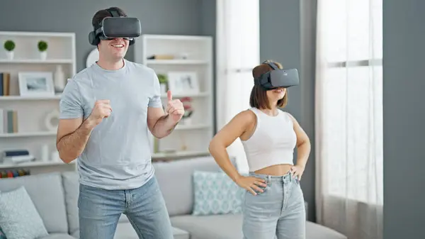Beautiful couple playing dancing video game using virtual reality glasses at home