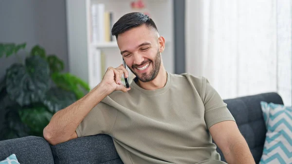 Jonge Spaanse Man Aan Telefoon Thuis Zittend Bank — Stockfoto